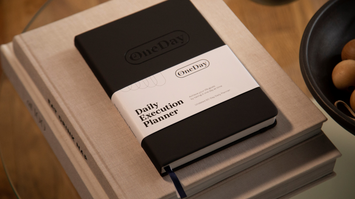 Daily Execution Planner on table with books